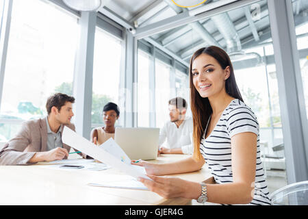Cheerful sucessful young woman on business meeting in conference room Stock Photo