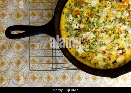 Fritatta with garden vegetables for breakfast served in a cast iron pan Stock Photo