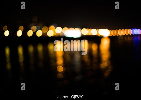 Beautiful blurred city lights with bokeh effect reflected on water background Stock Photo