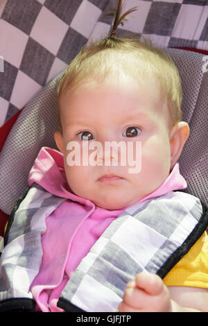 little newborn baby girl rests in the car seat Stock Photo