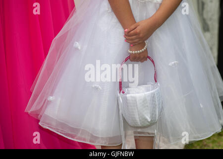 Hands of the flower girl with her pail Stock Photo