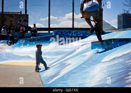 A child skateboarder and a BMXer in a Brussels skate park, Belgium Stock Photo
