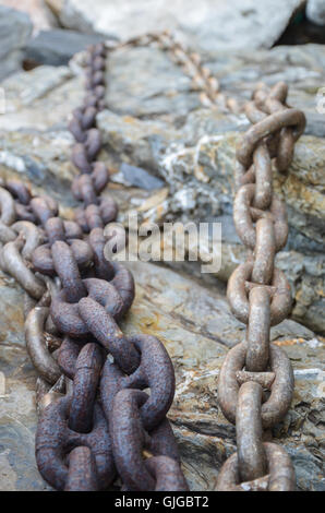 Anchor chain hanging over a stone quay, on the shore of Riomaggiore, Cinque Terre, Liguria Region, Italy Stock Photo