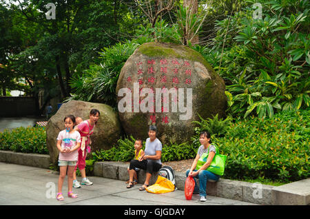 Locals are resting in the Yiexiu Park, that hosts the famous Statue of Five Goats of Guangzhou, China. Stock Photo