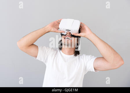 Cheerful man using virtual reality device Stock Photo