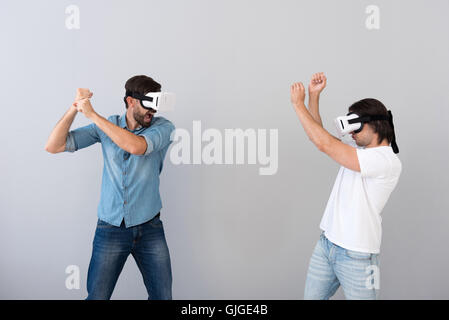 Serious involved men using virtual reality glasses Stock Photo