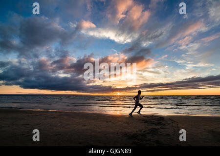 One man running at sunset on Wasaga Beach. Stock Photo