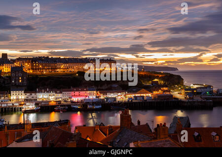 Whitby harbour and town, at night, with a dramatic sunset behind. In Whitby, North Yorkshire, England. On 12th August 2016. Stock Photo
