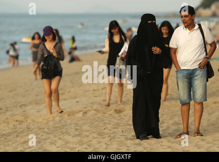 Penang, MALAYSIA. 24th Feb, 2016. Muslim women, wearing full burqas, and men enjoy a day at the beach in Penang, Malaysia on February 21, 2016. The mayor of Cannes in southern France has banned full-body swimsuits known as ''burkinis'' from the beach, citing public security concerns and fears. © Stephen Shaver/ZUMA Wire/Alamy Live News Stock Photo