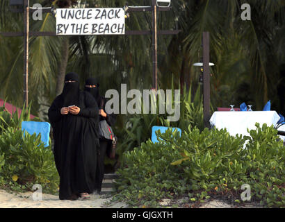 Penang, MALAYSIA. 24th Feb, 2016. Muslim women, wearing full burqas, enjoy a day at the beach in Penang, Malaysia on February 21, 2016. The mayor of Cannes in southern France has banned full-body swimsuits known as ''burkinis'' from the beach, citing public security concerns and fears. © Stephen Shaver/ZUMA Wire/Alamy Live News Stock Photo