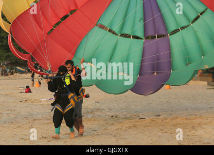 Penang, MALAYSIA. 24th Feb, 2016. A Muslim woman wearing a full burqa parasails with the aid of a male instructor during a day at the beach in Penang, Malaysia on February 21, 2016. The mayor of Cannes in southern France has banned full-body swimsuits known as ''burkinis'' from the beach, citing public security concerns and fears. © Stephen Shaver/ZUMA Wire/Alamy Live News Stock Photo