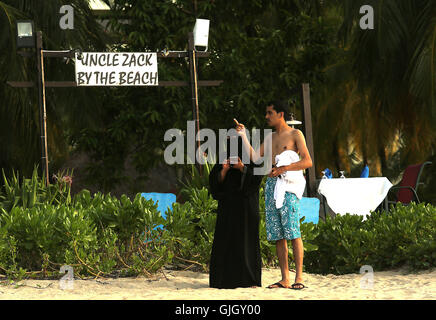 Penang, MALAYSIA. 24th Feb, 2016. Muslim women, wearing full burqas, and men enjoy a day at the beach in Penang, Malaysia on February 21, 2016. The mayor of Cannes in southern France has banned full-body swimsuits known as ''burkinis'' from the beach, citing public security concerns and fears. © Stephen Shaver/ZUMA Wire/Alamy Live News Stock Photo