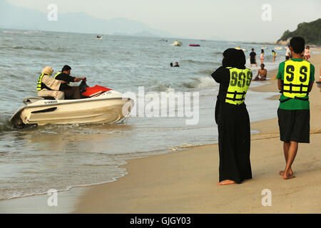 Penang, MALAYSIA. 24th Feb, 2016. A Muslim woman wearing a full burqa rides a WaverRunner with a man during a day at the beach in Penang, Malaysia on February 21, 2016. The mayor of Cannes in southern France has banned full-body swimsuits known as ''burkinis'' from the beach, citing public security concerns and fears. © Stephen Shaver/ZUMA Wire/Alamy Live News Stock Photo