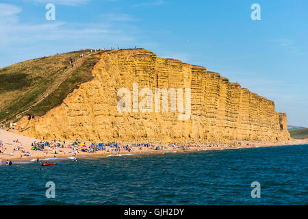 West Bay, Dorset, UK. 16th August, 2016. Landslide danger.  A packed beach below East Cliff at West Bay in Dorset hours before a cliff fall which closed the beach late this evening.  Holiday makers are seen close to the base of the cliff along a stretch which has had numerous landslides and rock falls.  Picture: Graham Hunt/Alamy Live News