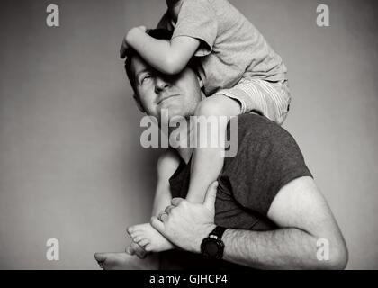 Boy sitting on his father's shoulders Stock Photo