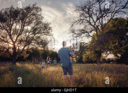 Father and four children walking in rural landscape at dusk, Texas, United States Stock Photo