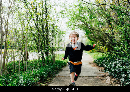 Boy running along pavement Stock Photo