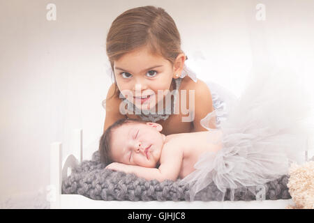 Portrait of a girl with newborn baby sister Stock Photo