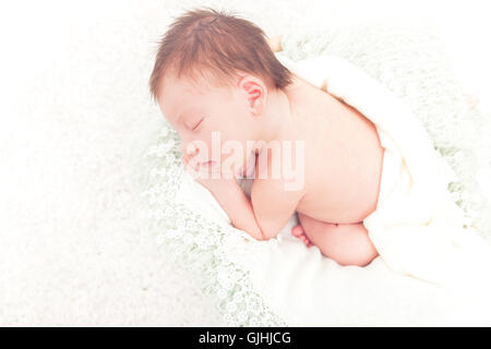 Portrait of a newborn baby girl wrapped in a blanket sleeping Stock Photo