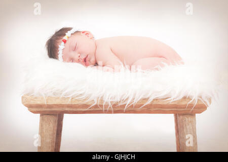 Portrait of a newborn baby girl sleeping on fluffy rug Stock Photo