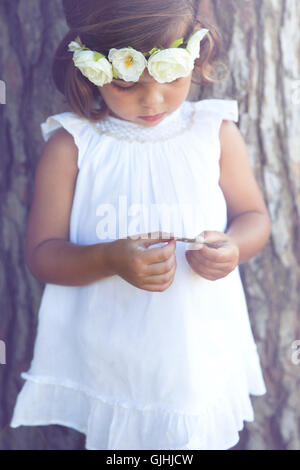 Portrait of a girl standing by tree wearing flower headdress Stock Photo