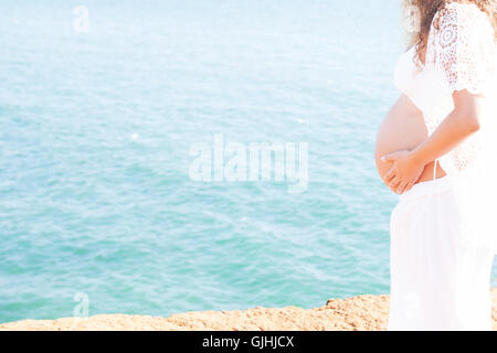 Portrait of a pregnant woman standing by sea Stock Photo