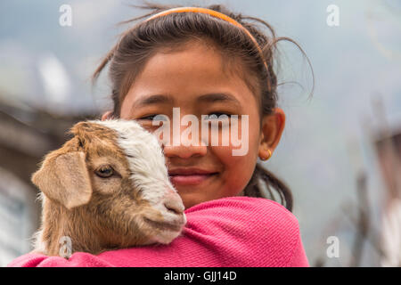 Nepal, girl with goat in mountain village. Stock Photo