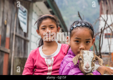 Nepal, girls with goat in mountain village. Stock Photo