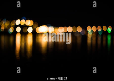 Beautiful blurred city lights with bokeh effect reflected on water background Stock Photo