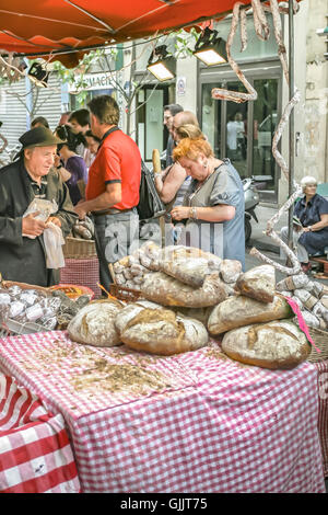 Woman buying bread at an outdoor stall in Paris, France Stock Photo