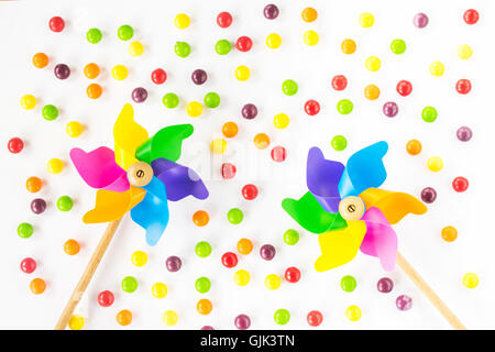 Colorful pinwheels and candies on white background. Top view. Flat lay Stock Photo