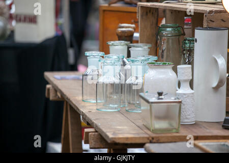 London, UK - July 17, 2016.  Spitalfields Antic Market. old bottles and pharmacy jars on a wooden chest of drawers for sale