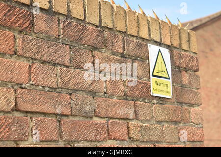 Warning Sign on a Brick Wall Stock Photo