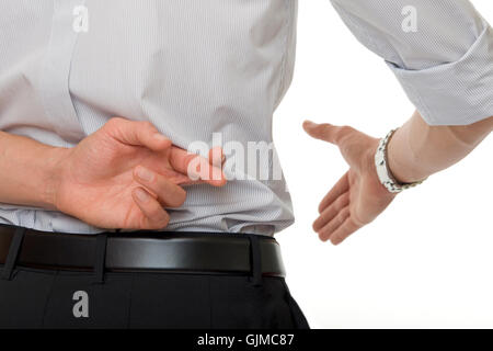 crossed fingers at handshake Stock Photo