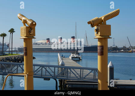 Abstract Photo Of A Catamaran Tied To The Public Pier With The Historic RMS Queen Mary, Moored In Long Beach Harbor, California. Stock Photo