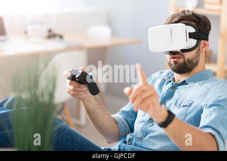 Pleasant concentrated man playing video games Stock Photo