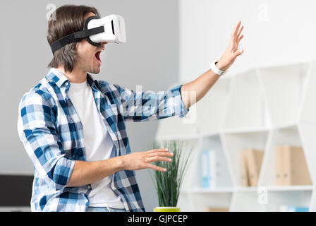 Emotional man using virtual reality device Stock Photo