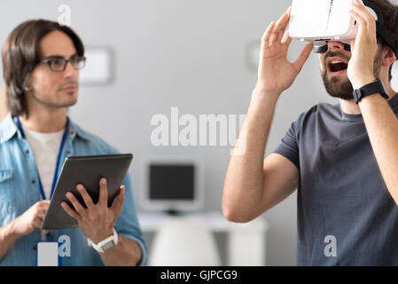 Pleasant colleagues testing virtual reality glasses Stock Photo