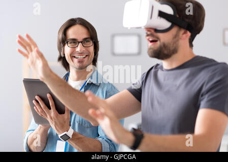 Cheerful colleagues testing virtual reality glasses Stock Photo