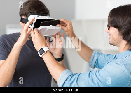 Pleasant cheerful colleagues testing virtual reality glasses Stock Photo