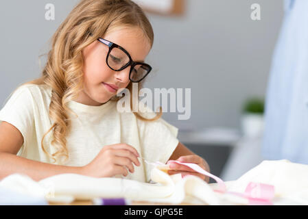 Thoughtful girl sewing new dress Stock Photo