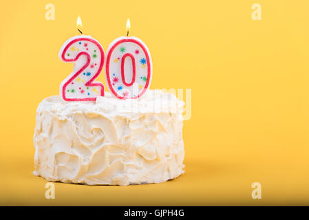 Frosted cake with the number 20 lighted candles Stock Photo
