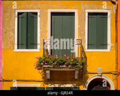 The traditional colourful painted buildings,with wooden window shutters and venetian blinds, on the island of Burano. Italy Stock Photo