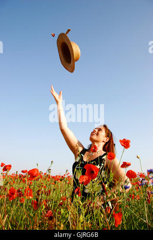 woman in poppy field hat throwing up Stock Photo