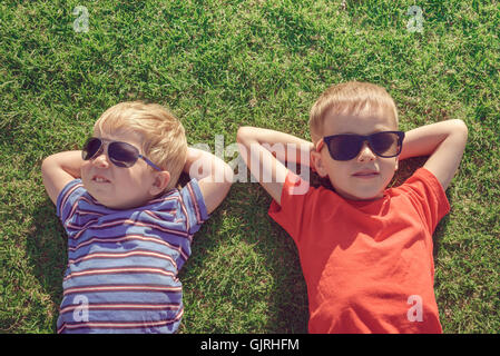 Happy smiling kids relaxing on the grass, top view. Color-toning applied Stock Photo