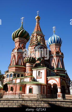 A red church with three domes and a cross on top. The roof is made of ...