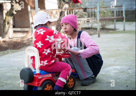 Jalabat, Kyrgyzstan: Children playing in a garden in a village. Stock Photo