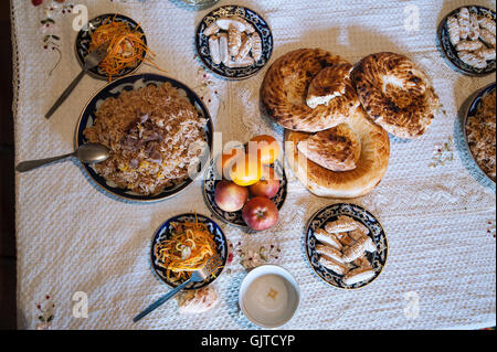 Kyrgyzstan, Jalabat: A typical Central Asian dinner, rice with some meat, green tea, salad, fruits and some sweets. Stock Photo