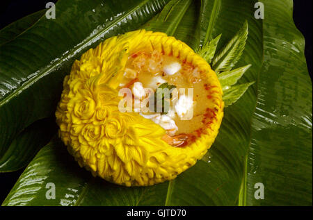 Thai shrimp spicy soup serve in bowl carved from pumpkin Stock Photo