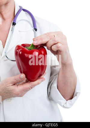 Doctor holding large red bell pepper looks like heart is in the hands, isolated on white background Stock Photo